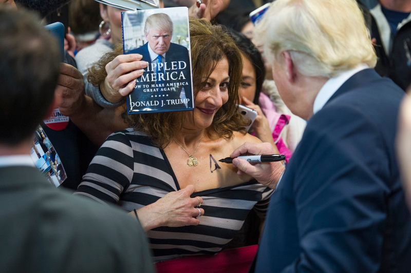 Donald Trump signs a woman’s chest at a December 2015 rally in Manassas, Virginia (Associated Press)